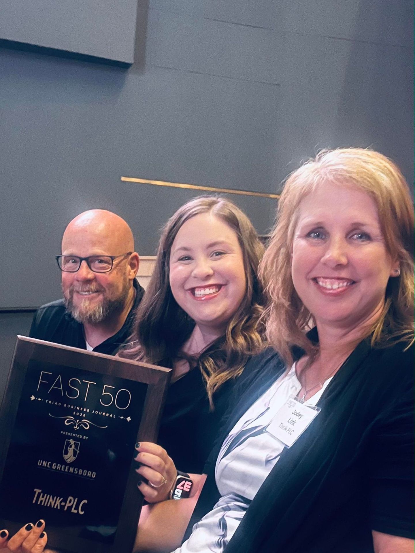 Members of the Think-PLC team with the Fast 50 plaque